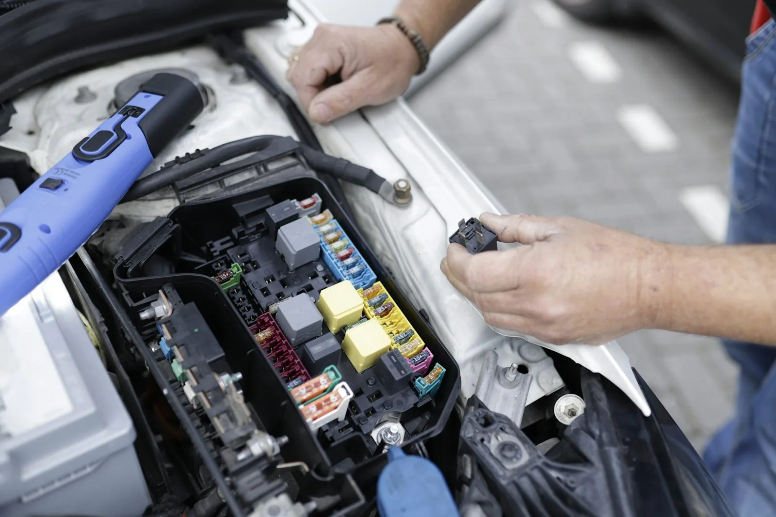 Technician inspecting automotive fuses and electrical connections