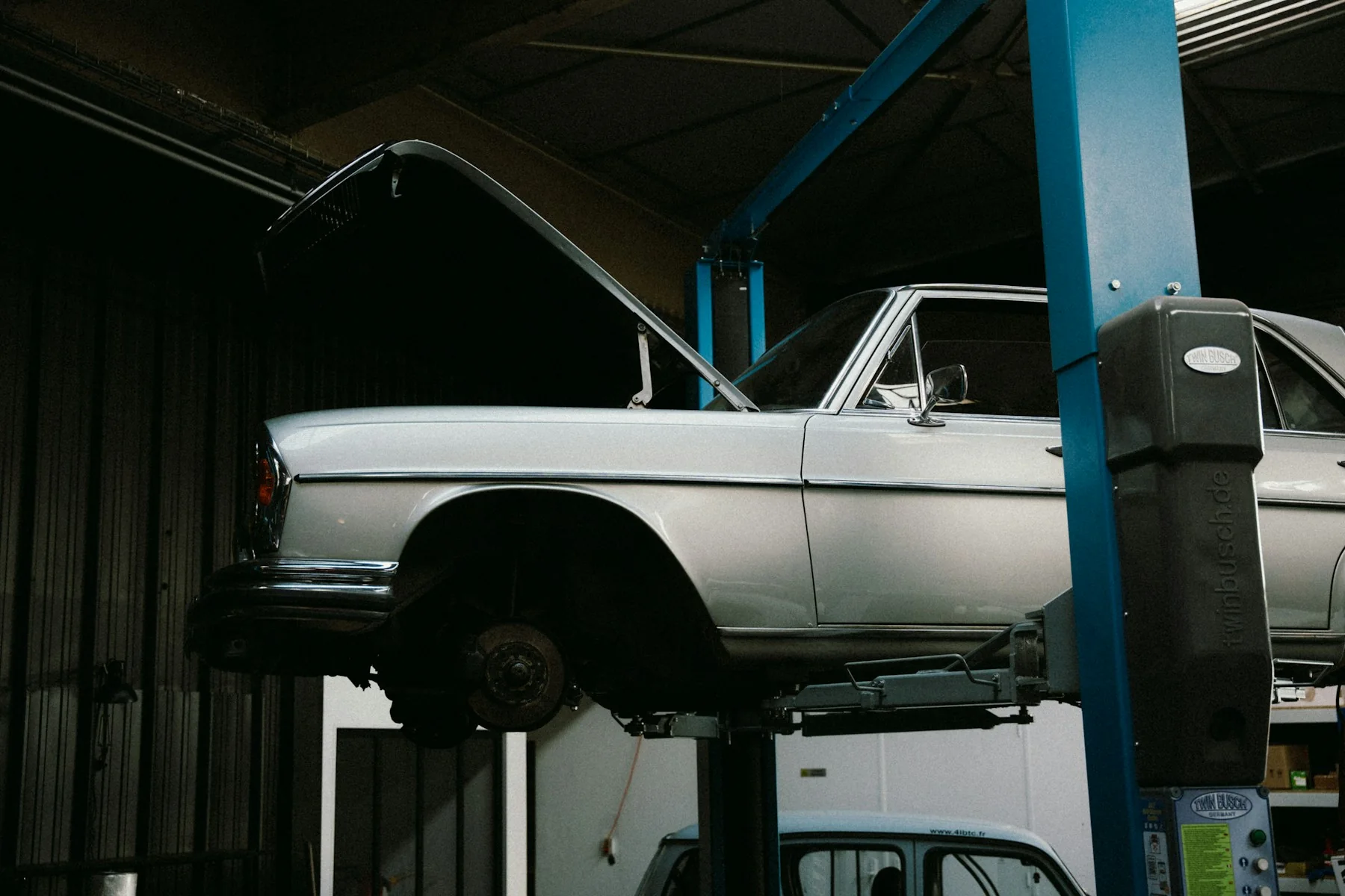 Vehicle raised on a lift inside an automotive workshop